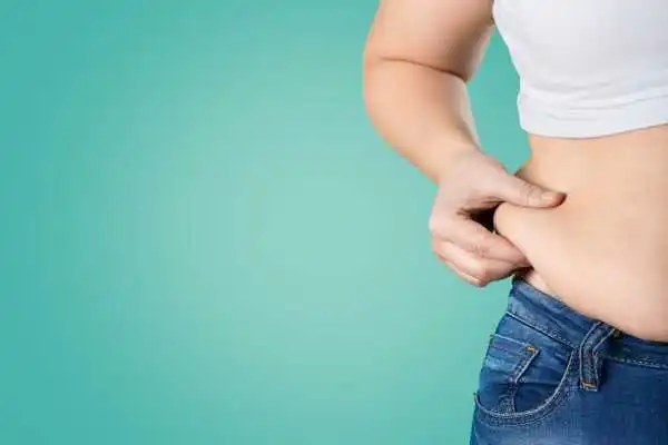 Image of woman pinching her love handles to show weight gain Princes Risborough